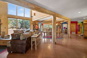 Living room featuring suspended lighting, a high ceiling, and tile patterned flooring