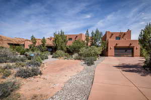 View of front facade with stucco siding, driveway, and an attached garage