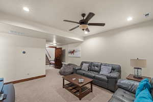 Living room featuring recessed lighting, light colored carpet, and a ceiling fan