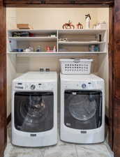 Laundry area with washer and clothes dryer and baseboards