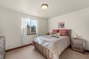 Bedroom with light colored carpet and baseboards