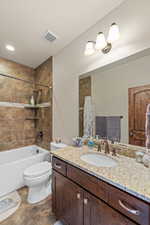 Full bathroom featuring vanity, shower / tub combo, and dark stone finish floors