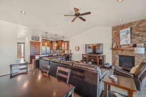 Living room featuring a ceiling fan, a fireplace, recessed lighting, and vaulted ceiling