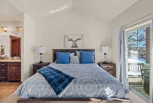 Bedroom featuring access to exterior, vaulted ceiling, and connected bathroom