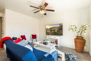 Living room with light carpet and ceiling fan