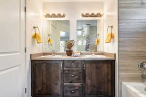 Bathroom with double vanity and tub / shower combination