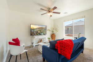 Carpeted living area with baseboards and ceiling fan