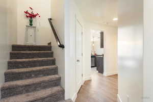 Stairs featuring wood finished floors and recessed lighting