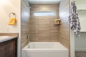 Bathroom with vanity and shower / washtub combination