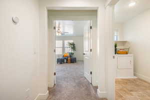 Hall featuring light carpet and washer / clothes dryer
