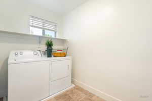 Laundry area with baseboards and washing machine and clothes dryer