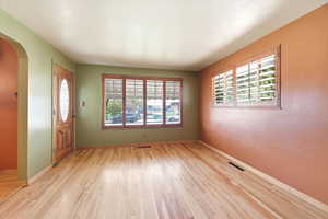 Foyer entrance with arched walkways and light wood finished floors