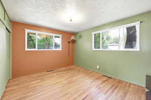 Unfurnished bedroom featuring light wood-style floors, a closet, and a textured ceiling