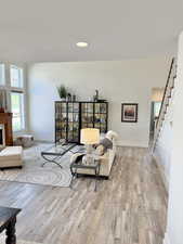 Living room with plenty of natural light, light wood-style flooring, and recessed lighting
