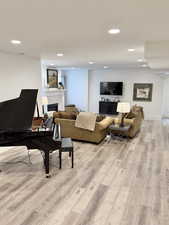 Living room featuring a fireplace, light wood-style flooring, and recessed lighting