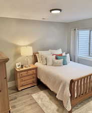 Bedroom with light wood finished floors and baseboards