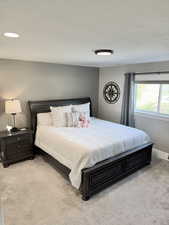 Bedroom with light carpet and a textured ceiling