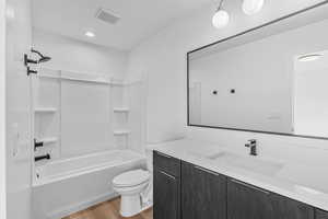 Photos of a finished unit - Full bathroom with vanity, light wood finished floors, and washtub / shower combination