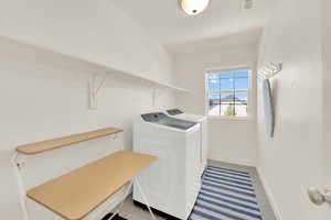 Laundry room featuring baseboards and washing machine and dryer