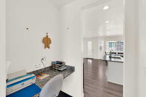 Kitchen with a desk, recessed lighting, dark wood-style floors, dark stone counters, and white cabinetry
