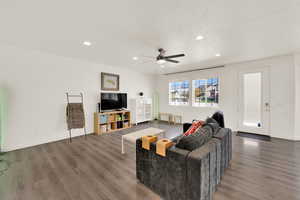 Living area featuring dark wood finished floors, ceiling fan, and recessed lighting