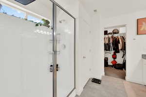 Full bath with a walk in closet, vanity, and a shower stall