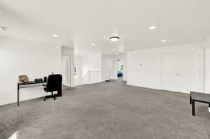 Carpeted office space featuring recessed lighting and baseboards