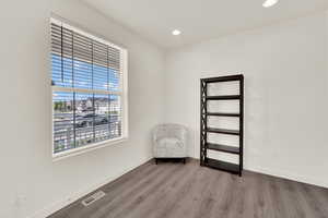 Unfurnished room with wood finished floors and recessed lighting