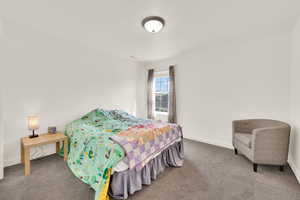 Bedroom featuring carpet flooring and baseboards