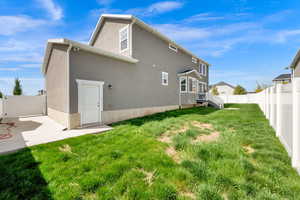 Back of house with a fenced backyard, stucco siding, and a gate