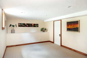 Empty room with carpet floors, a textured ceiling, and recessed lighting