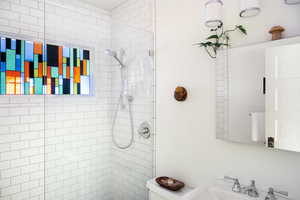 Full bath featuring toilet and a tile shower