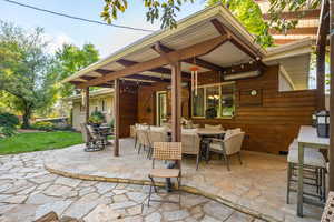 Backyard patio with hardwired heaters, firepit, dining space and kitchenette