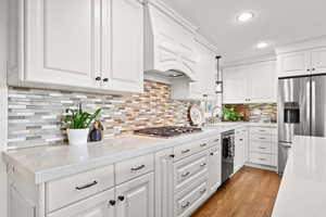 Kitchen featuring gas cooktop, double ovens, quartz countertops and updated cabinetry