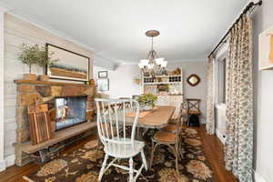 Dining room featuring hardwood floors, wood burning fireplace & access to backyard patio