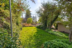 View of fenced yard and mature landscaping