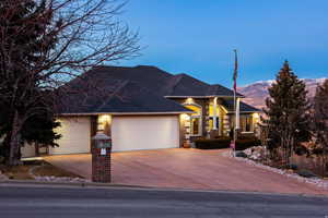 View of front facade featuring brick siding, a garage, concrete driveway, and roof with shingles