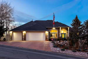 View of front facade featuring an attached garage, brick siding, driveway, and a shingled roof