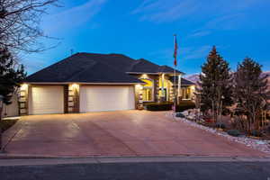 View of front of property featuring a garage, concrete driveway, and brick siding