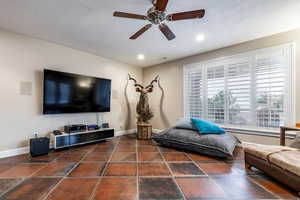 Living room featuring ceiling fan, a textured ceiling, and recessed lighting