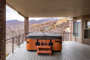 Deck featuring a hot tub and a mountain view