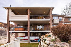 Back of property featuring brick siding and a balcony