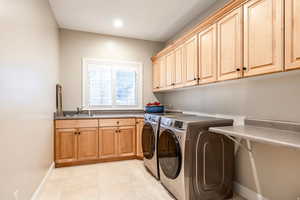 Laundry area featuring washer and clothes dryer, cabinet space, light tile patterned flooring, and recessed lighting