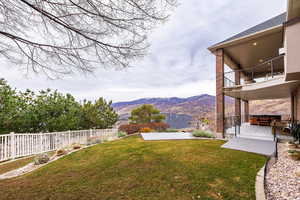 Fenced backyard with a balcony and a deck with mountain view