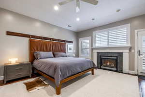Bedroom featuring wood finished floors, a ceiling fan, a tile fireplace, recessed lighting, and access to exterior