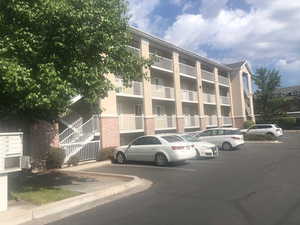 View of apartment building / complex with uncovered parking