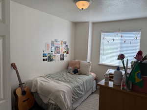Carpeted bedroom with a textured ceiling