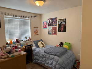 Carpeted bedroom featuring a textured ceiling