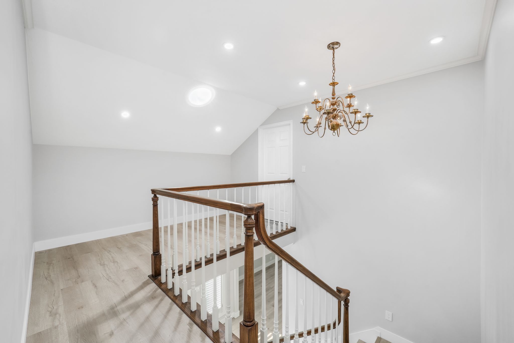 Stairs featuring a chandelier and wood finished floors