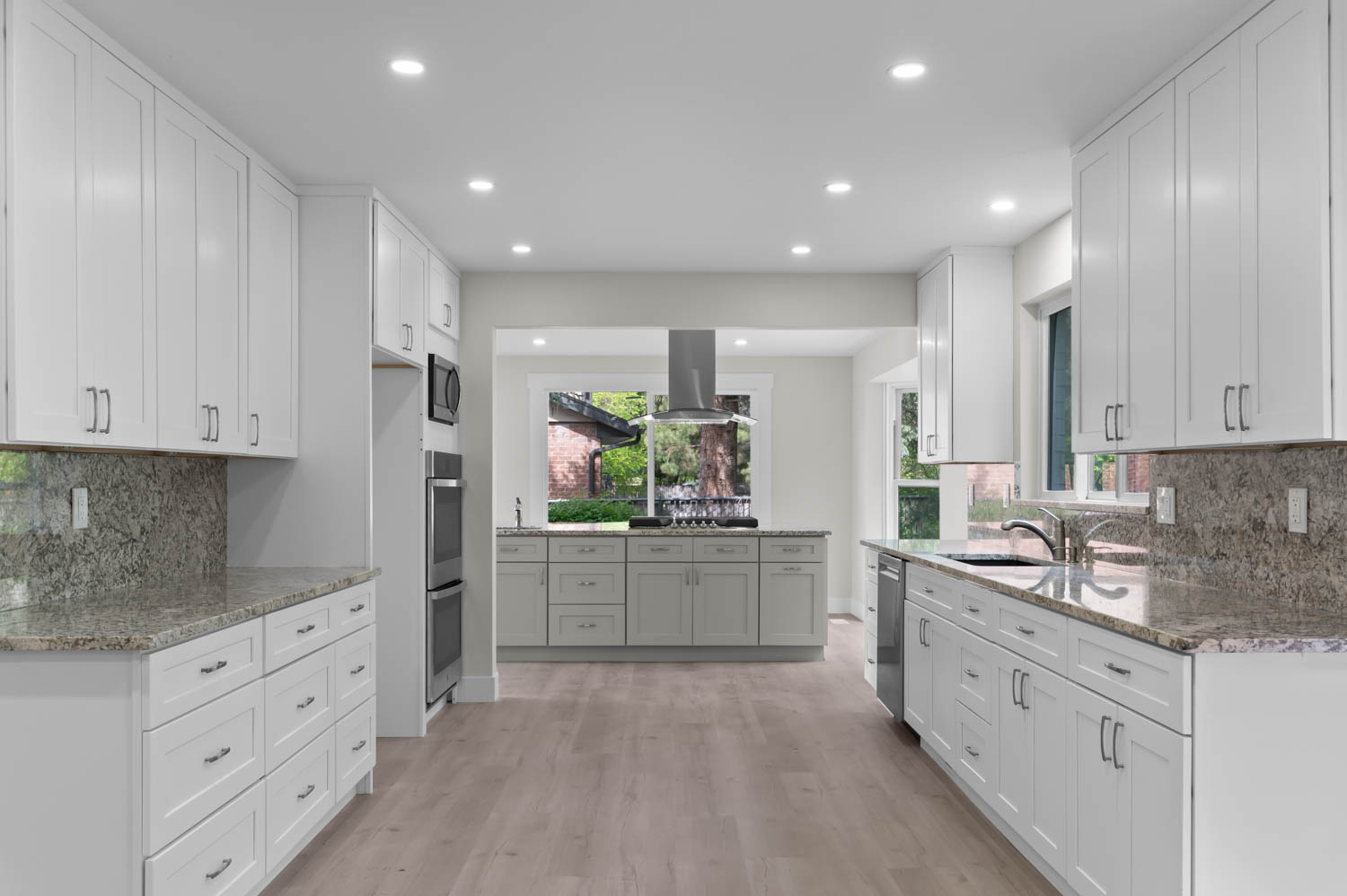 Kitchen with tasteful backsplash, dark stone counters, recessed lighting, white cabinetry, and light wood-style flooring